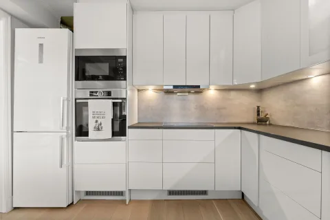 Une cuisine moderne en cours de rénovation avec des outils de chantier posés sur un plan de travail en marbre.