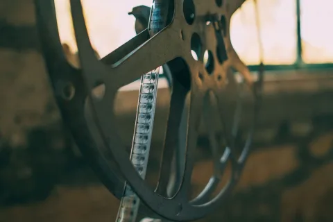 Un projecteur de cinéma rétro diffusant un faisceau de lumière dorée dans une salle obscure