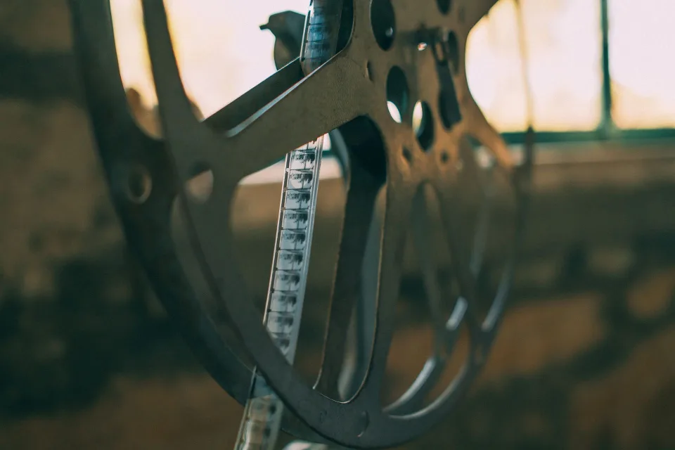 Un projecteur de cinéma rétro diffusant un faisceau de lumière dorée dans une salle obscure