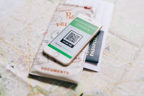Un smartphone pose sur un passeport affichant des documents de voyage numeriques.