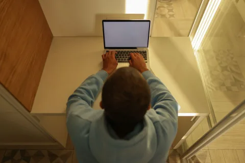 Une personne assise devant un ordinateur portable affichant des options de sécurité et de protection des données.