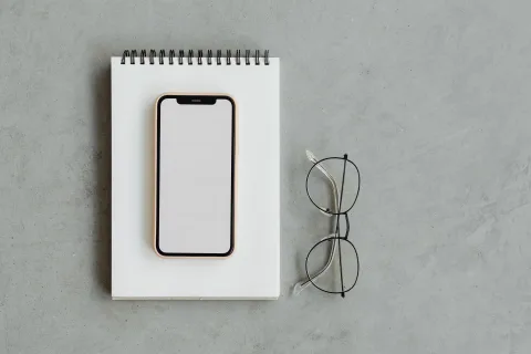 Un smartphone posé sur une table en métal à l'ombre pour refroidir sa batterie.