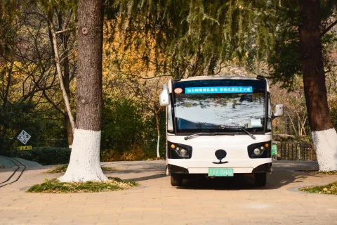 Un petit minibus de transport public stationné sur la place d'un village rural français.