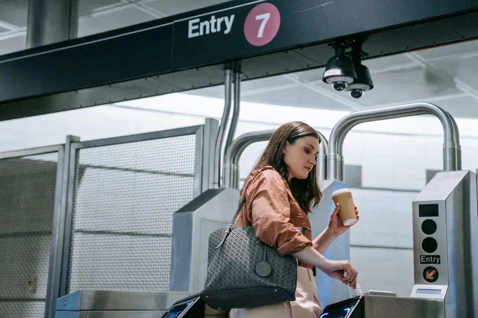 Une personne validant son passage au portique de métro avec son smartphone sans contact.