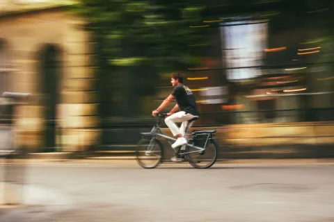 Un salarié se déplace à vélo électrique en ville pour aller au travail