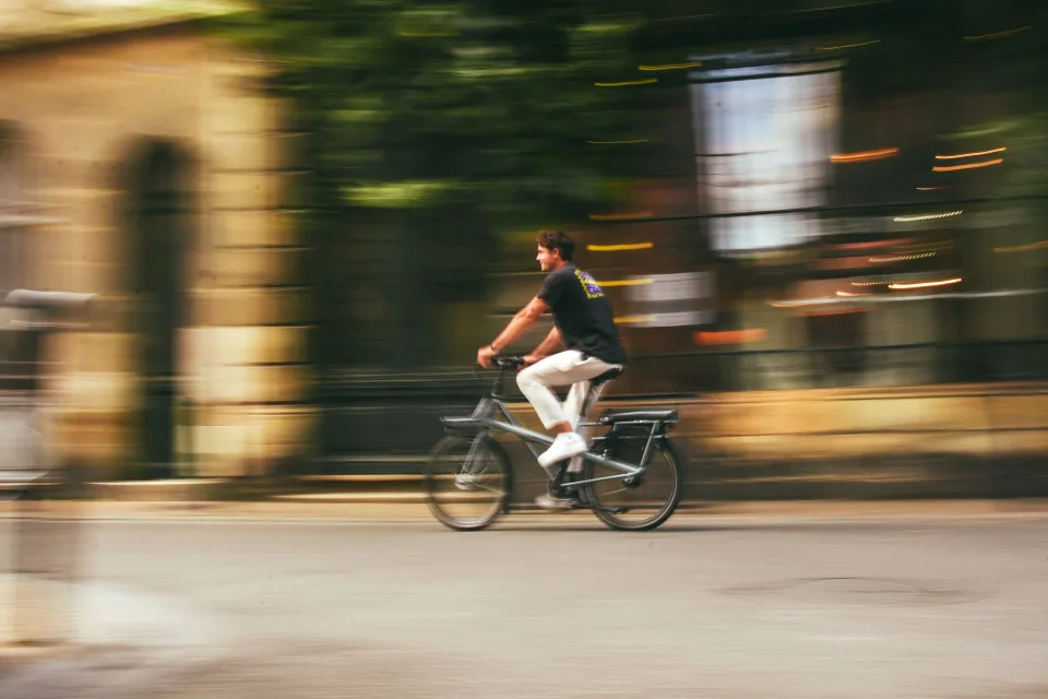Un salarié se déplace à vélo électrique en ville pour aller au travail