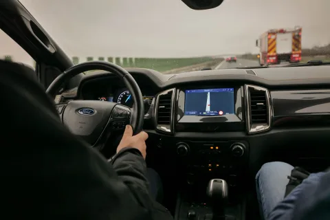 Une voiture s'approchant d'un portique de péage automatique avec des panneaux indiquant l'obligation de vignette en Autriche.
