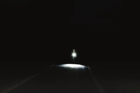 Cycliste urbain circulant de nuit avec un éclairage avant puissant et des bandes réfléchissantes