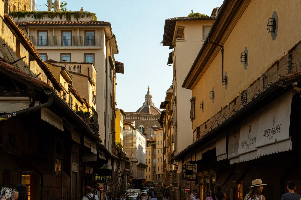 Une voyageuse marche dans une ruelle médiévale pavée en Europe.