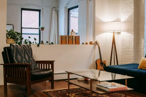 Un coin lecture chaleureux avec un tapis, des coussins au sol et une lampe d'appoint diffusant une lumière douce.