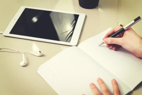 Une personne utilise une tablette et un stylet pour organiser des schémas et des notes numériques complexes.