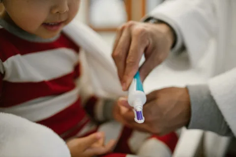 Un tube de dentifrice percé déposé à l'intérieur du réservoir de la chasse d'eau des toilettes.