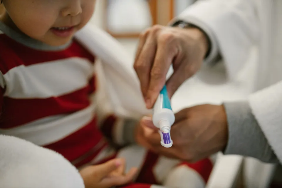 Un tube de dentifrice percé déposé à l'intérieur du réservoir de la chasse d'eau des toilettes.