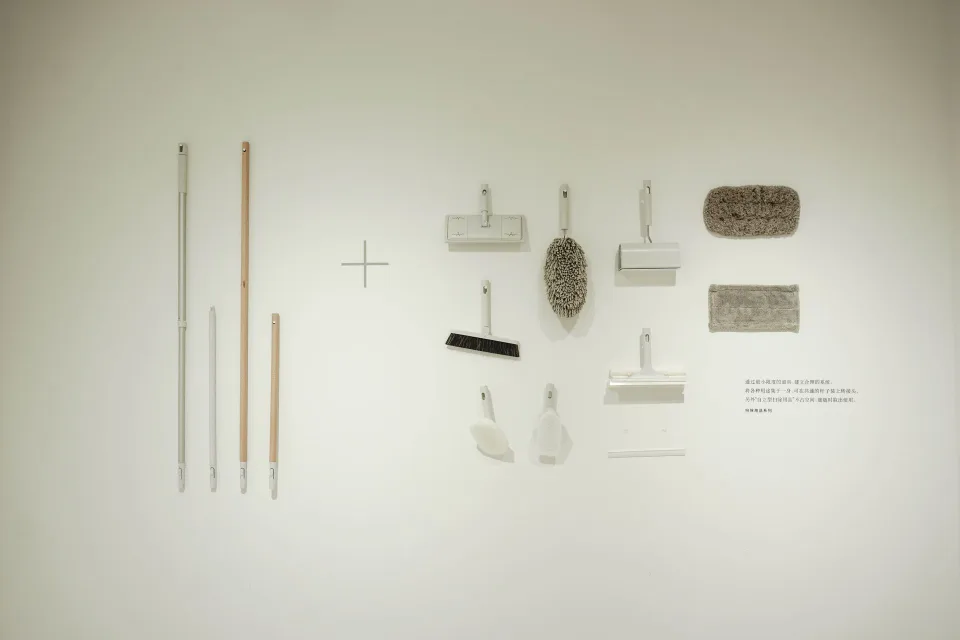 Une personne utilise un goupillon flexible pour dépoussiérer l'intérieur d'un radiateur blanc.