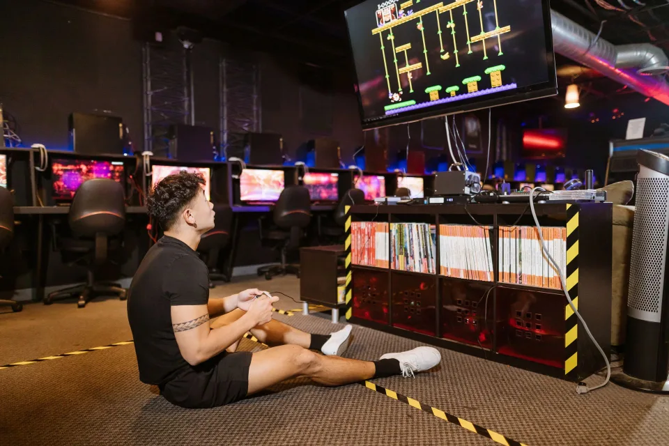 Une personne devant un écran affichant une large bibliothèque de jeux vidéo numériques.