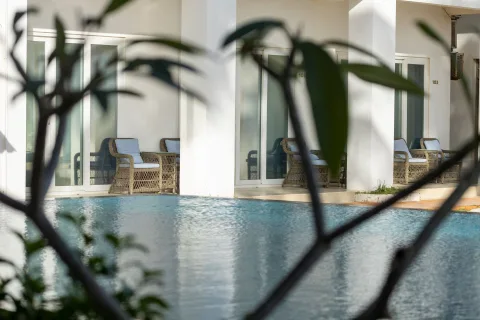 Une piscine intérieure luxueuse avec des colonnes en marbre et des transats élégants.